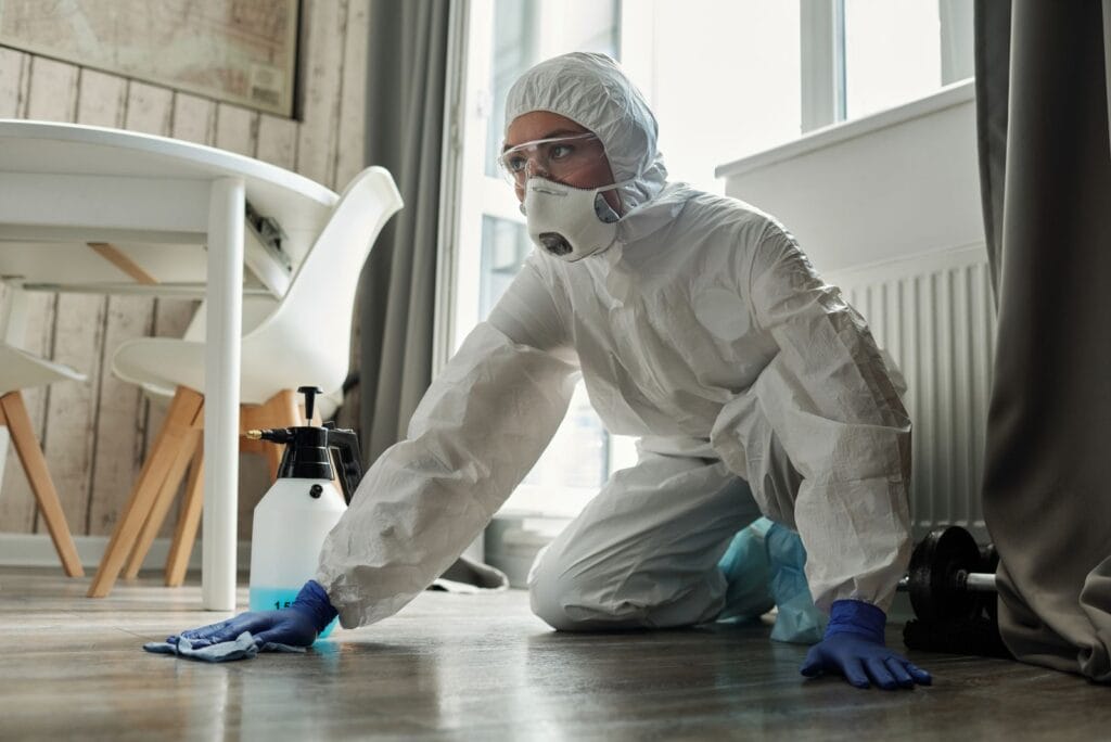 Asbestos abatement technicians in protective suits removing insulation