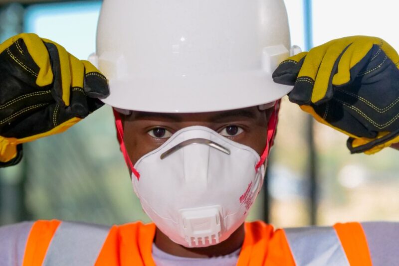Technician wearing a hard hat and respirator mask before taking samples